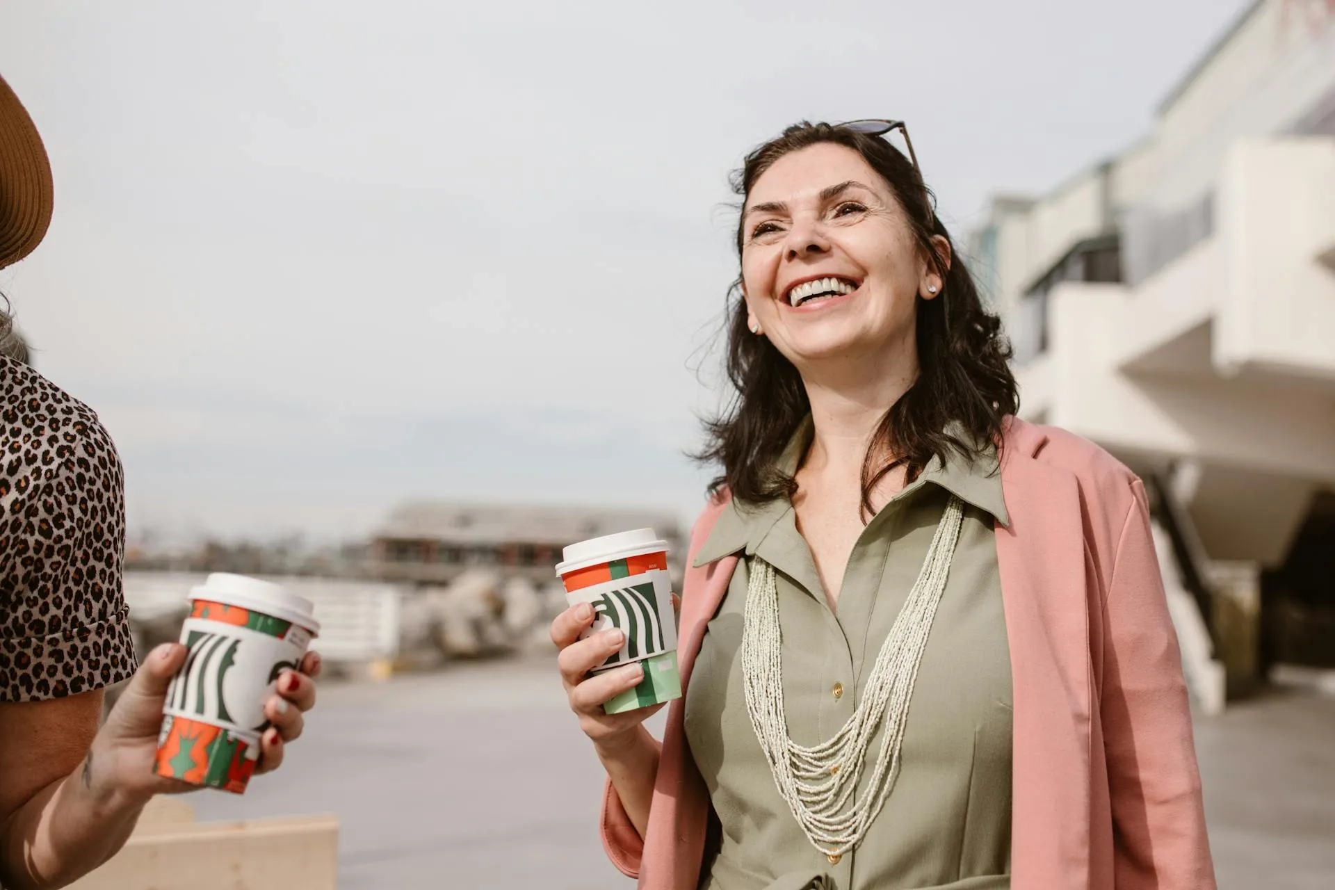 Person smiling and holding a cup of coffee
