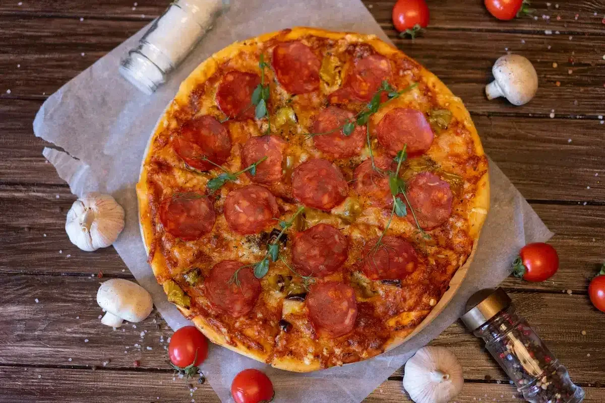 Pizza with salami, garlic, tomato and mushrooms